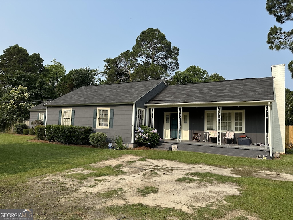 202 Geneva St, Dublin, GA 31021 - view of front facade featuring covered porch, a front lawn, and a chimney