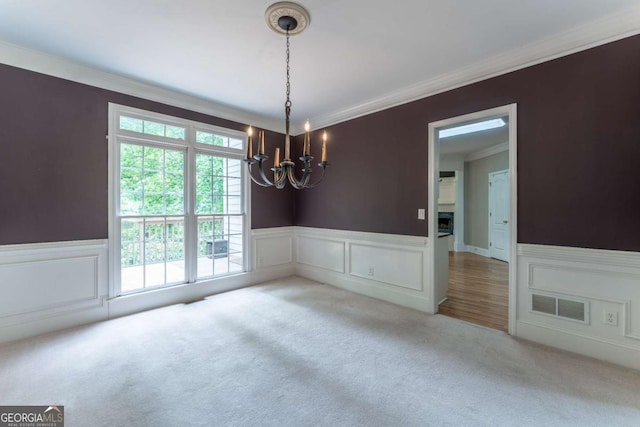 3801 Stonebriar Ln, Duluth, GA 30097 - carpeted empty room featuring a chandelier, wainscoting, crown molding, and a decorative wall