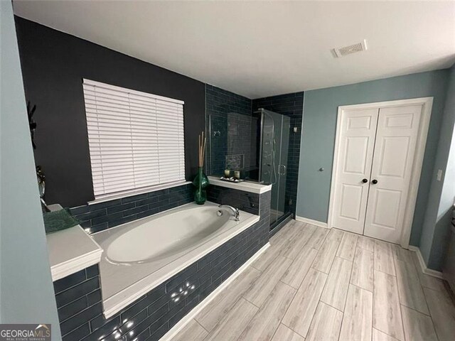 2030 Hydrangea Ln, Austell, GA 30106 - full bathroom with a bath, a shower stall, and wood finished floors