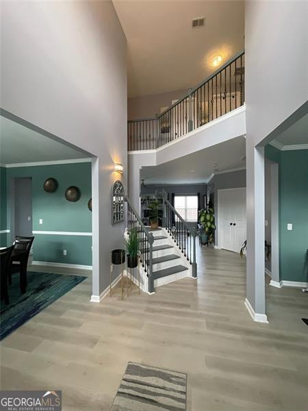 2030 Hydrangea Ln, Austell, GA 30106 - stairway with a towering ceiling, wood finished floors, and ornamental molding