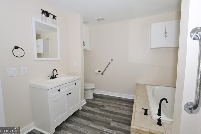 3434 Union Point Rd, Union Point, GA 30669 - bathroom featuring vanity, a garden tub, wood finished floors, toilet, and baseboards