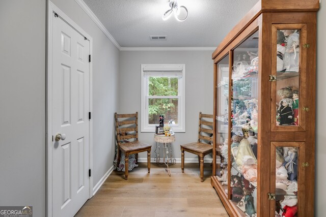 212 Teepee Trl, Whitesburg, GA 30185 - living area with light wood-type flooring, a textured ceiling, and ornamental molding