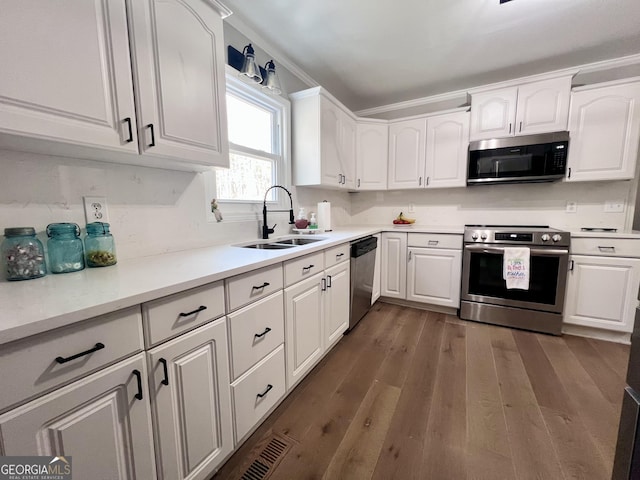 212 Teepee Trl, Whitesburg, GA 30185 - kitchen with appliances with stainless steel finishes, white cabinetry, dark wood finished floors, and ornamental molding
