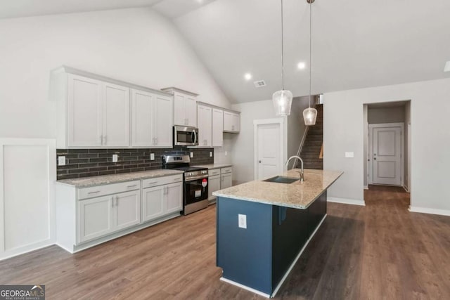 4300 Links Blvd, Jefferson, GA 30549 - kitchen featuring stainless steel appliances, vaulted ceiling, a sink, decorative backsplash, and light stone countertops
