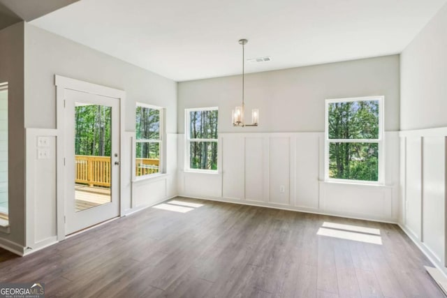4300 Links Blvd, Jefferson, GA 30549 - unfurnished dining area with a decorative wall, a chandelier, wood finished floors, and a wainscoted wall