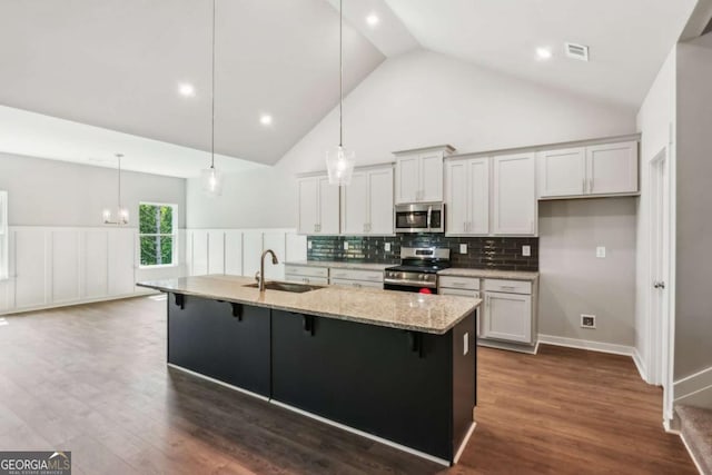 4300 Links Blvd, Jefferson, GA 30549 - kitchen with appliances with stainless steel finishes, a sink, a breakfast bar area, decorative backsplash, and high vaulted ceiling