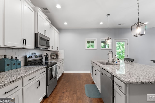 8 Saint Charles Ave, Sharpsburg, GA 30277 - kitchen featuring stainless steel appliances, a sink, backsplash, an island with sink, and baseboards
