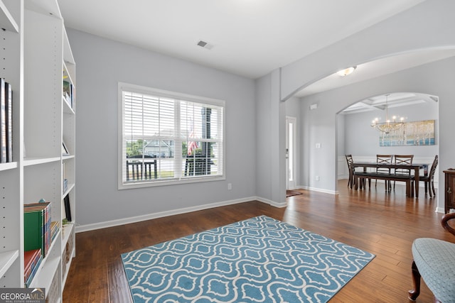 8 Saint Charles Ave, Sharpsburg, GA 30277 - living area with arched walkways, a chandelier, wood finished floors, and baseboards