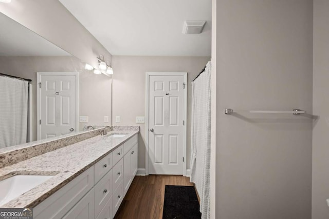 1672 Meadow Lark Ln, Gainesville, GA 30501 - bathroom with double vanity, wood finished floors, and curtained shower