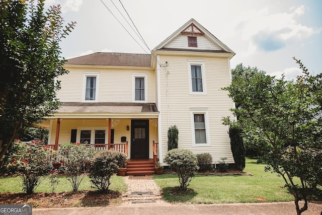428 Elm St, Barnesville, GA 30204 - victorian home featuring a porch, a front lawn, and roof with shingles