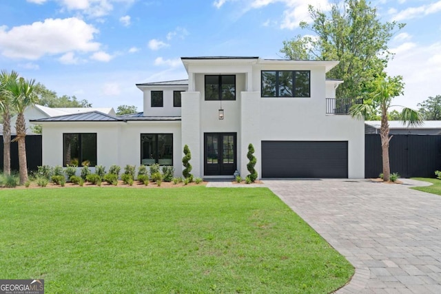 616 Neptune Way, Saint Simons, GA 31522 - modern home featuring french doors, a standing seam roof, a garage, stucco siding, and a front yard