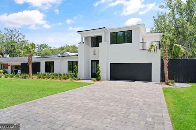 616 Neptune Way, Saint Simons, GA 31522 - modern home with an attached garage, a balcony, stucco siding, and decorative driveway
