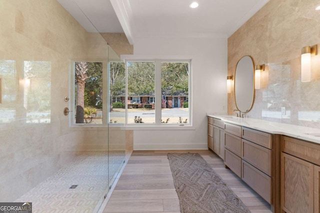 616 Neptune Way, Saint Simons, GA 31522 - bathroom with double vanity, a tile shower, and wood finished floors