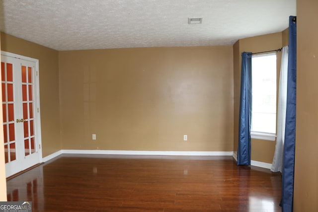 3255 Hunters Crossing Pt, Lithonia, GA 30038 - empty room featuring french doors, dark wood finished floors, baseboards, healthy amount of natural light, and a textured ceiling