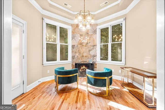 4670 Hamden Forest Dr SW, Atlanta, GA 30331 - living area with a chandelier, a raised ceiling, wood finished floors, ornamental molding, and a lit fireplace