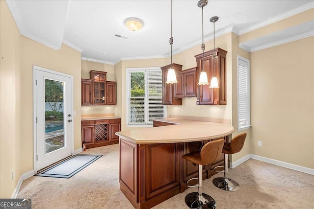 4670 Hamden Forest Dr SW, Atlanta, GA 30331 - kitchen featuring brown cabinets, a peninsula, a breakfast bar, pendant lighting, and glass insert cabinets