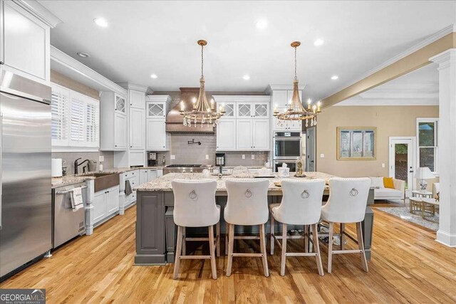 4670 Hamden Forest Dr SW, Atlanta, GA 30331 - kitchen featuring stainless steel appliances, a chandelier, decorative backsplash, plenty of natural light, and crown molding