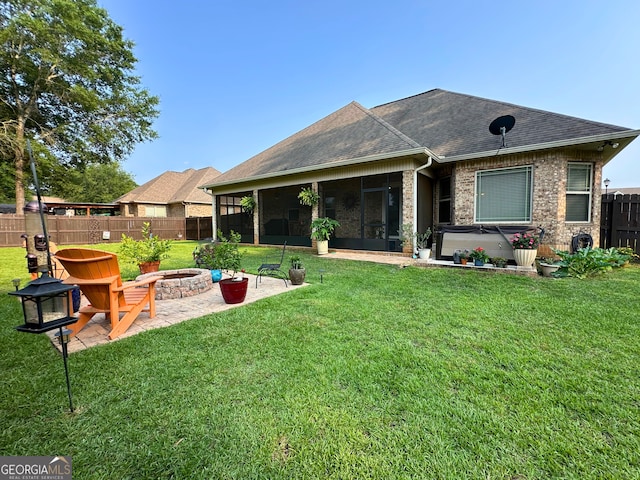 307 Legacy Park Dr, Perry, GA 31069 - back of house featuring a fire pit, a hot tub, a sunroom, roof with shingles, and a fenced backyard