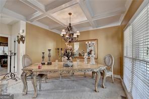 2123 Floral Ridge Dr, Dacula, GA 30019 - dining area featuring coffered ceiling, beam ceiling, plenty of natural light, and a chandelier