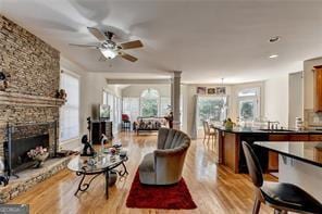 2123 Floral Ridge Dr, Dacula, GA 30019 - living area with light wood-style floors, a ceiling fan, and a stone fireplace