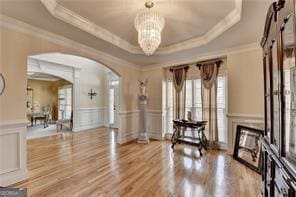 2123 Floral Ridge Dr, Dacula, GA 30019 - entryway featuring arched walkways, a raised ceiling, crown molding, a decorative wall, and a chandelier