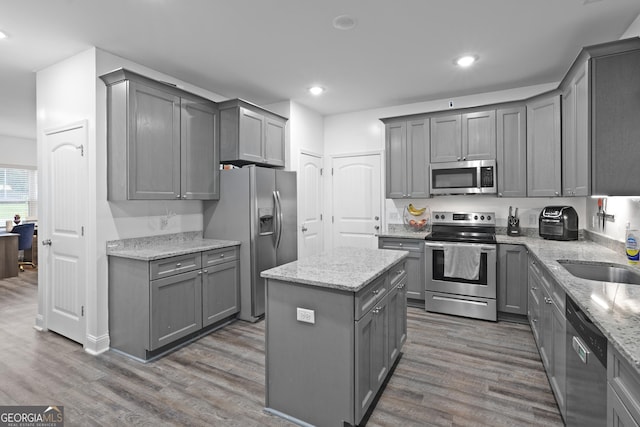 102 Brookstone Way, Rincon, GA 31326 - kitchen with stainless steel appliances, gray cabinets, wood finished floors, a center island, and a sink