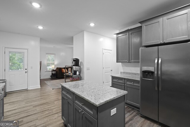 102 Brookstone Way, Rincon, GA 31326 - kitchen featuring stainless steel refrigerator with ice dispenser, wood finished floors, a center island, recessed lighting, and light stone countertops