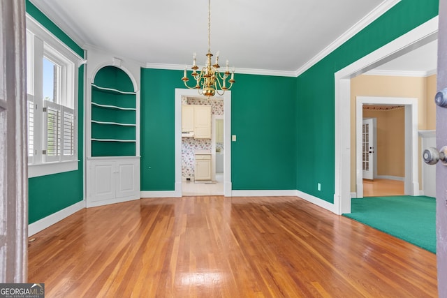 7443 Church St, Bartow, GA 30413 - unfurnished dining area featuring a chandelier, wood finished floors, ornamental molding, built in shelves, and baseboards