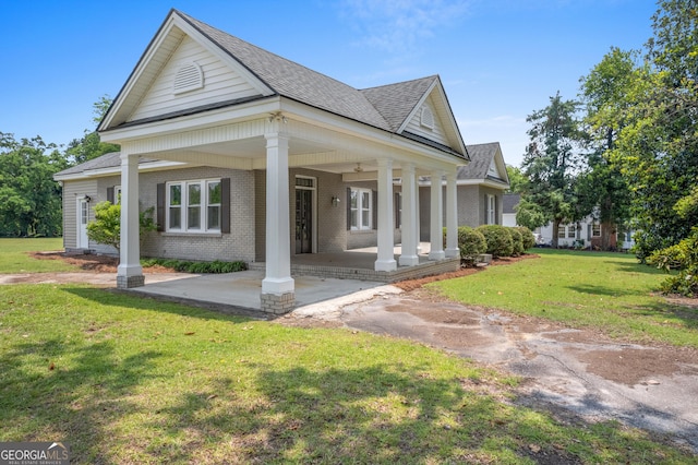 7443 Church St, Bartow, GA 30413 - greek revival house featuring brick siding, roof with shingles, a front yard, and a porch