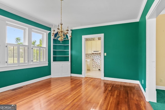 7443 Church St, Bartow, GA 30413 - unfurnished dining area with a chandelier, wood finished floors, baseboards, and crown molding