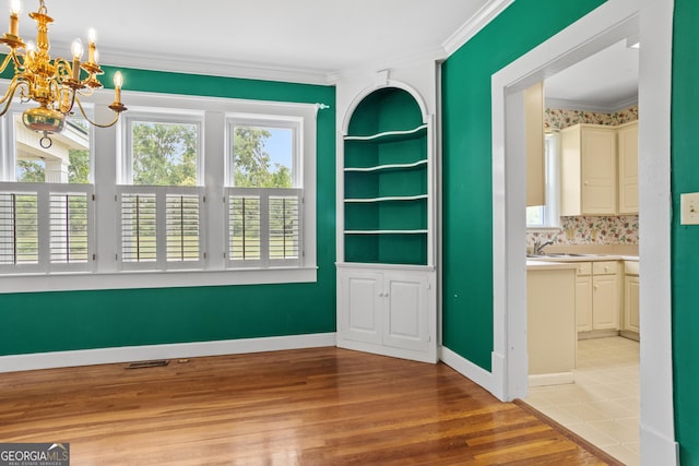 7443 Church St, Bartow, GA 30413 - empty room with a chandelier, ornamental molding, healthy amount of natural light, wood finished floors, and built in features