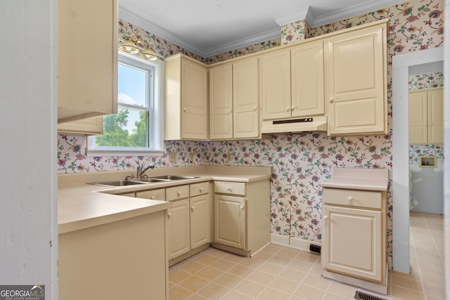 7443 Church St, Bartow, GA 30413 - kitchen featuring wallpapered walls, under cabinet range hood, cream cabinetry, ornamental molding, and light tile patterned flooring