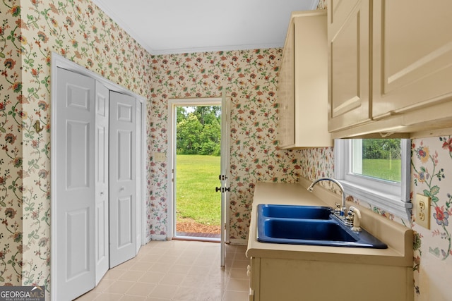 7443 Church St, Bartow, GA 30413 - kitchen featuring cream cabinets, a sink, wallpapered walls, light countertops, and plenty of natural light