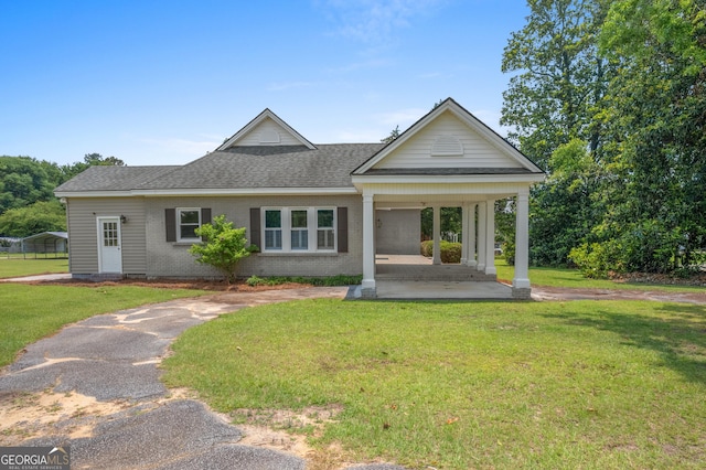 7443 Church St, Bartow, GA 30413 - view of front of home featuring a front yard, brick siding, a shingled roof, driveway, and a carport