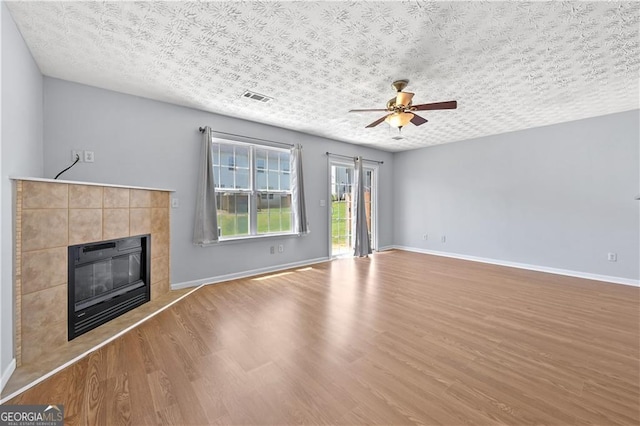 695 Georgetown Ct, Jonesboro, GA 30236 - unfurnished living room featuring a tiled fireplace, wood finished floors, ceiling fan, and baseboards