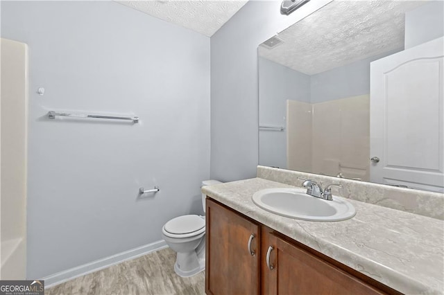 695 Georgetown Ct, Jonesboro, GA 30236 - bathroom with wood finished floors, a textured ceiling, vanity, toilet, and baseboards