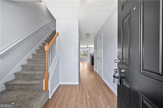 695 Georgetown Ct, Jonesboro, GA 30236 - foyer entrance featuring wood finished floors, stairway, a textured ceiling, baseboards, and ceiling fan