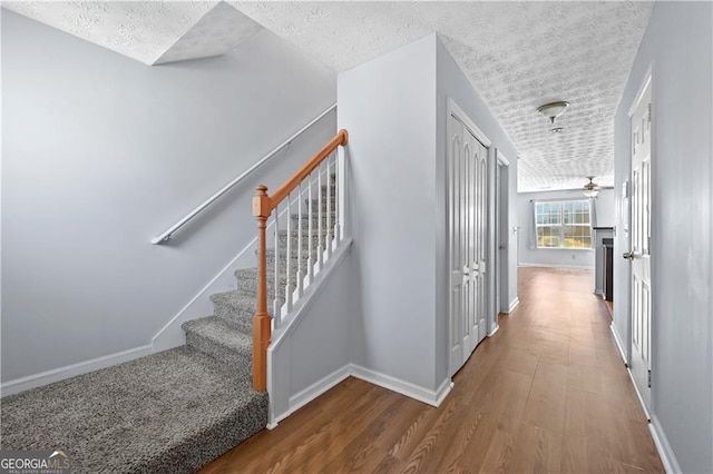 695 Georgetown Ct, Jonesboro, GA 30236 - corridor with a textured ceiling, wood finished floors, baseboards, and stairway