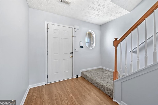 695 Georgetown Ct, Jonesboro, GA 30236 - foyer entrance featuring wood finished floors, stairway, a textured ceiling, and baseboards