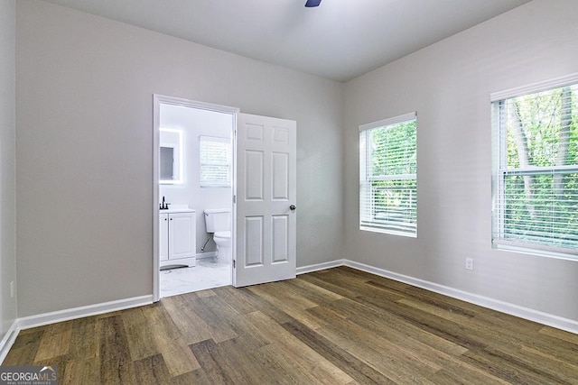 2065 Freeman St, Macon, GA 31201 - unfurnished bedroom featuring wood finished floors, baseboards, ensuite bath, and a sink