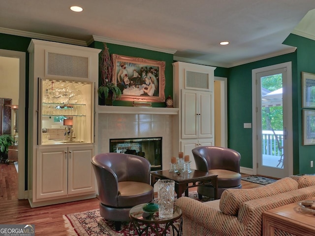 307 Worthing Ln, Mcdonough, GA 30253 - living room featuring crown molding, light wood finished floors, a tiled fireplace, and recessed lighting