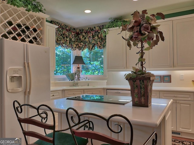 307 Worthing Ln, Mcdonough, GA 30253 - kitchen with white appliances, a breakfast bar, white cabinets, light countertops, and recessed lighting