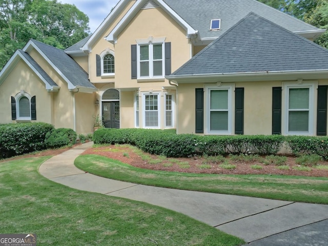 307 Worthing Ln, Mcdonough, GA 30253 - view of front facade with stucco siding, a front lawn, and roof with shingles