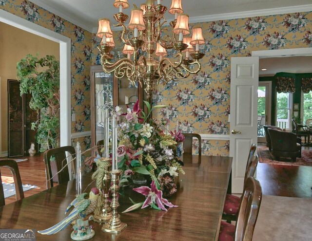 307 Worthing Ln, Mcdonough, GA 30253 - dining space with wallpapered walls, ornamental molding, a chandelier, and wood finished floors