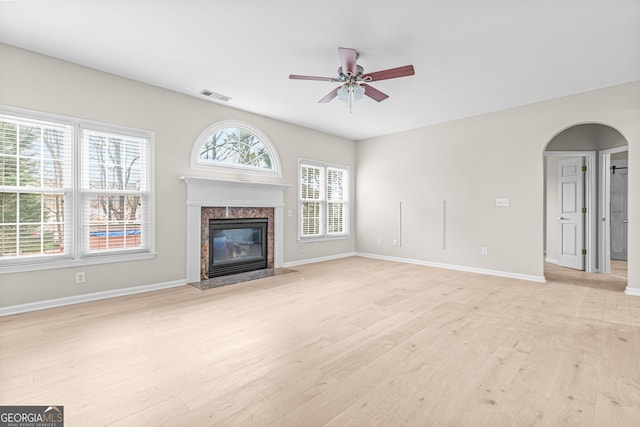 2030 Brook Meadow Dr, Alpharetta, GA 30005 - unfurnished living room with light wood finished floors, a ceiling fan, a high end fireplace, and arched walkways