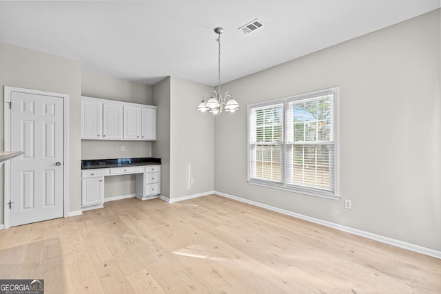 2030 Brook Meadow Dr, Alpharetta, GA 30005 - kitchen featuring built in study area, light wood-type flooring, white cabinetry, and decorative light fixtures