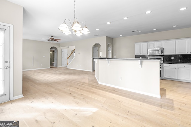 2030 Brook Meadow Dr, Alpharetta, GA 30005 - kitchen featuring stainless steel appliances, arched walkways, a kitchen bar, dark countertops, and white cabinets