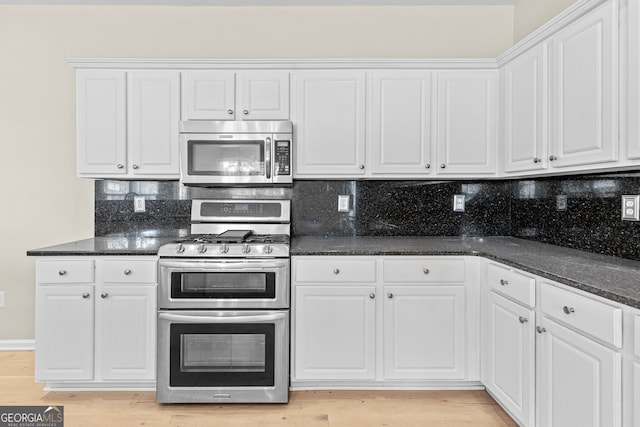 2030 Brook Meadow Dr, Alpharetta, GA 30005 - kitchen featuring stainless steel appliances, white cabinetry, decorative backsplash, light wood-style floors, and dark stone countertops