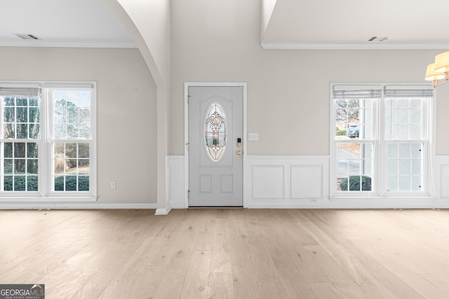 2030 Brook Meadow Dr, Alpharetta, GA 30005 - foyer featuring crown molding, arched walkways, light wood-style flooring, plenty of natural light, and wainscoting