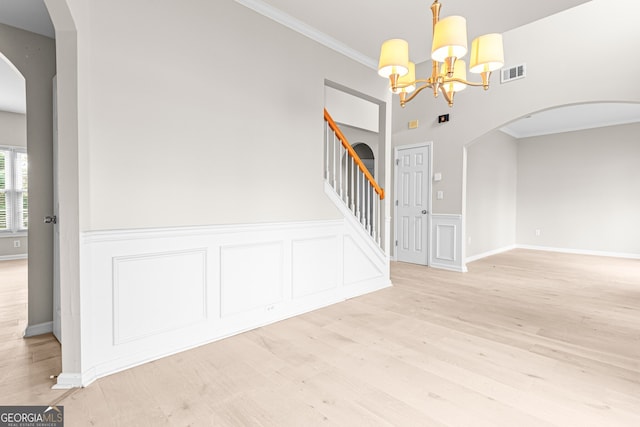 2030 Brook Meadow Dr, Alpharetta, GA 30005 - spare room featuring arched walkways, light wood-type flooring, crown molding, stairway, and a chandelier